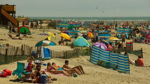 Day-trippers enjoying the sun on West Wittering beach near Chichester, West Sussex.