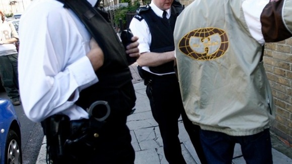 Police stop and search a man in Brixton, south London.