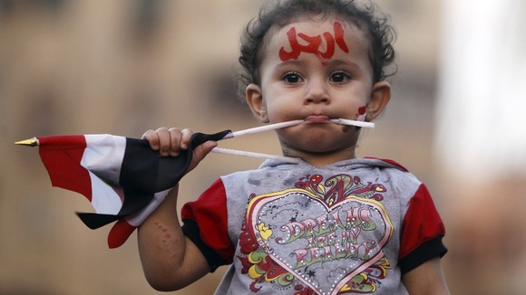 A girl with the colours of the Egyptian flag and the word 'leave' painted on her face is seen during yesterday's protests against Morsi.