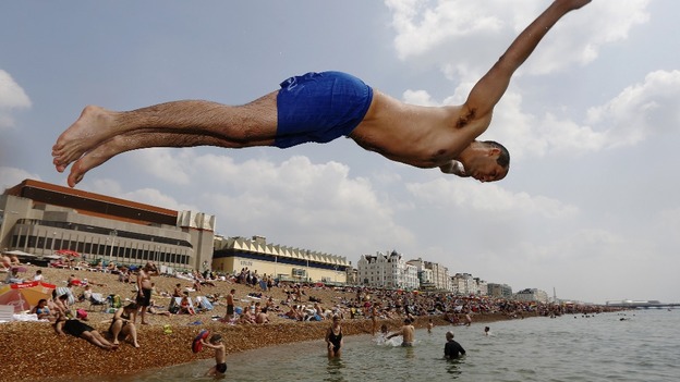 Marek Czyzowski from London dives into the sea at Brighton beach on Sunday. The recent hot weather is due to continue until this Sunday.