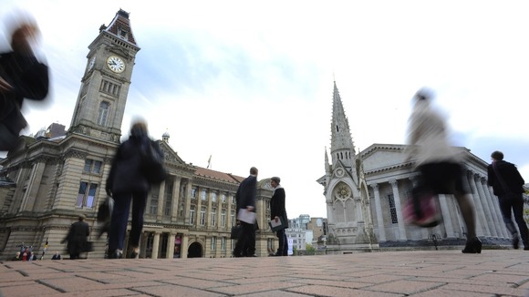 Commuters pass the Town Hall and Council House in Birmingham i