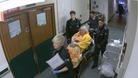 Old lady on bed-trolley in corridor pushed by paramedics