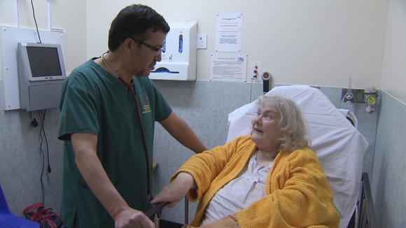 Doctor talks to old lady on hospital bed