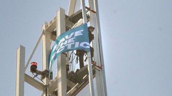 Wiola, 23, unfurls a banner at the top of the Shard