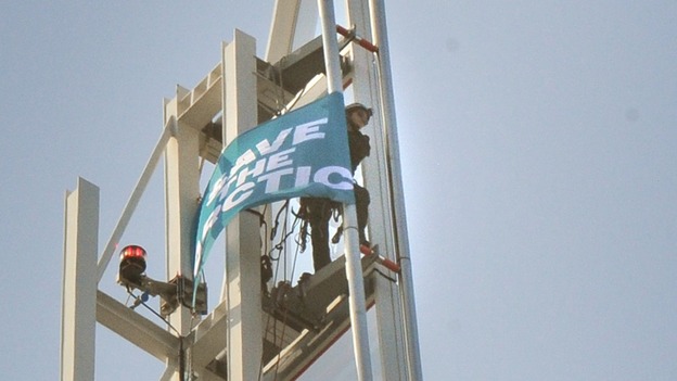 Wiola, 23, unfurls a banner at the top of the Shard