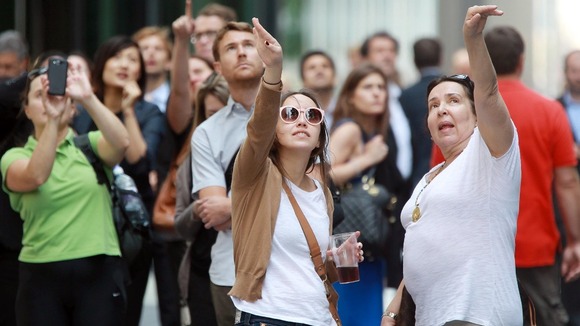 Onlookers watch as a group of six protesters scaling the Shard