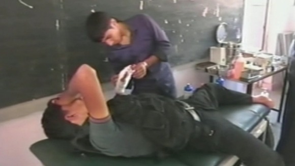 A medic tends to a bandage in a makeshift hospital in Aleppo, Syria