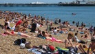 People enjoy the sunshine on Brighton Beach.