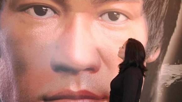 Shannon Lee stands in front of a picture of her father