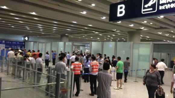 Policemen and security personnel are seen at the arrival gate B where an explosion occurred at Terminal 3.