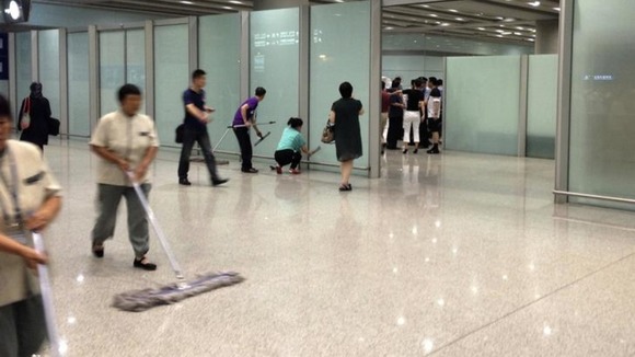 Staff at Beijing Capital International Airport clear up the aftermath of the explosion