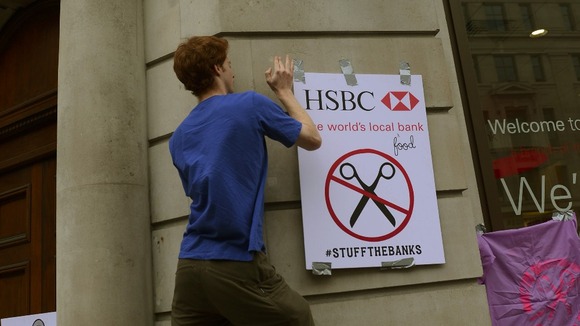 A protester re-brands a HSBC branch in London
