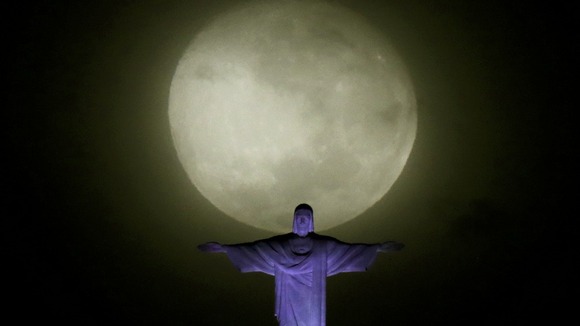 The moon and Christ the Redeemer statue pictured ahead the visit of Pope Francis in Rio de Janeiro.