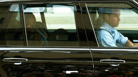 Kate can be seen smiling at her son as Prince William drives them to Kensington Palace yesterday.