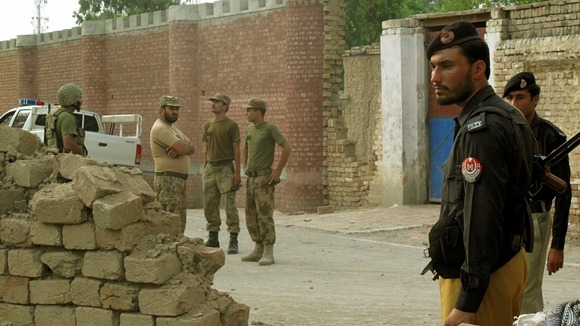 Policemen and ranger soldiers stand outside the prison following the Taliban attack.