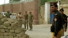 Policemen and ranger soldiers stand outside the prison following the Taliban attack.