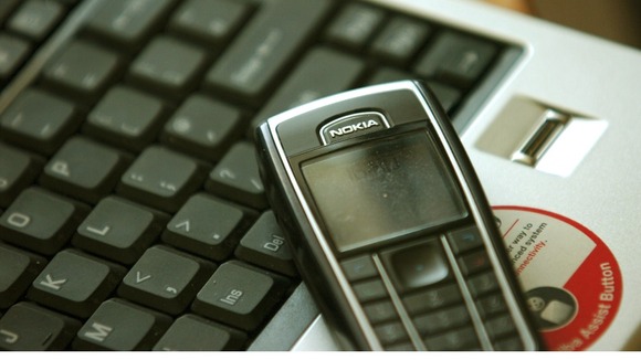 Stock photograph of a mobile phone and computer keyboard