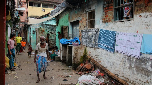 A man walks through a lane next to the house of former royal footman Badar Azim.
