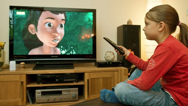 A girl watches a film on television.