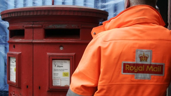 Royal Mail postman collecting from a post box
