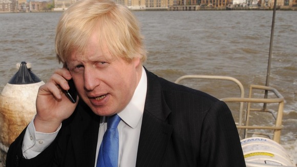 Boris Johnson guards his smartphone on a London Thames clipper