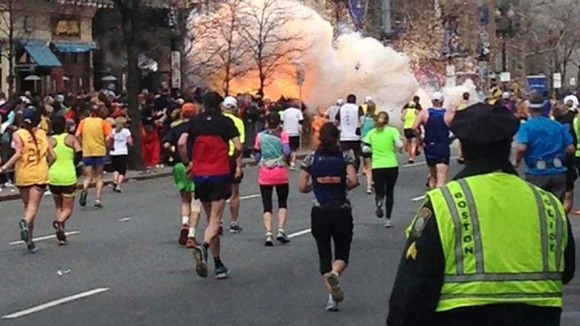 Runners continuing to run towards the finish line of the Boston Marathon as an explosion erupted near the finish line of the race.