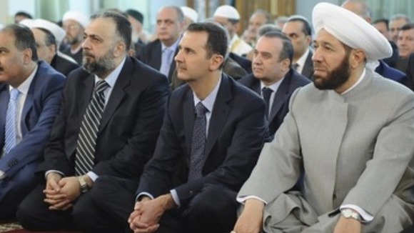 President Assad pictured praying after oppositions claims it shelled his motorcade.