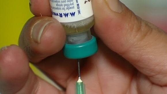 A doctor prepares an MMR vaccine