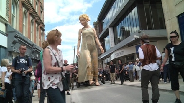 Shoppers stop to take pictures of the giant puppet