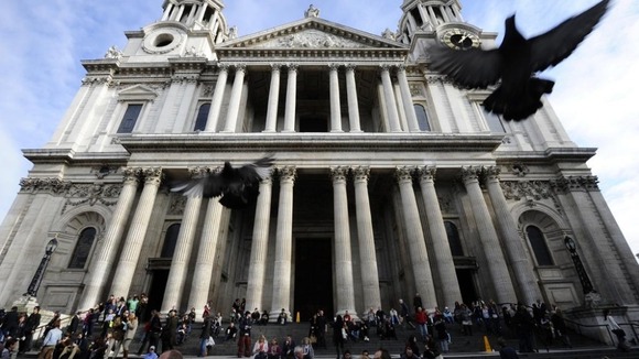 eople sit on the steps of St Paul's Cathedral as it reopens in London October 28, 2011.