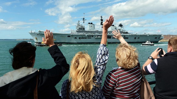 People waving off ship