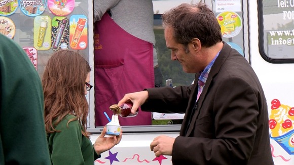 Man ppours syrup on lady's ice cream
