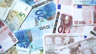 Euro notes scattered on a surface.