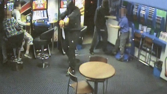 Two masked men threatened staff with a handgun and machete.
