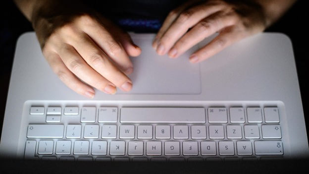 Stock photograph of a person typing on a computer keyboard.