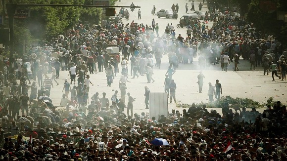 Muslim Brotherhood supporters run away from tear gas during clashes in Cairo on Friday