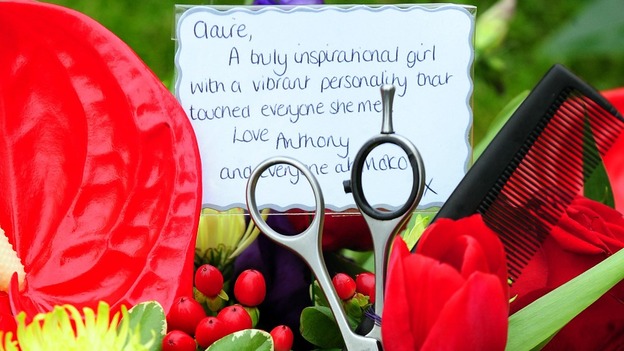 Scissors and a comb are left amongst floral tributes outside the funeral of hairdresser Claire Squires