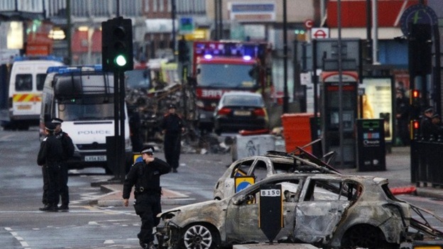 Police survey the aftermath of riots in Tottenham in 2011