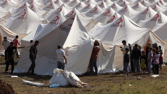 Syrian refugees set up a tent at a refugee camp in the Turkish border town of Boynuegin in Hatay province