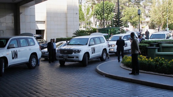 A convoy carrying UN weapons inspectors arrives at a Damascus hotel on 18 August