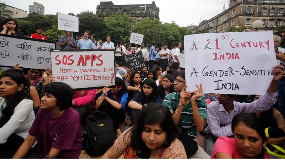 ournalists and students hold placards as they participate in a protest.