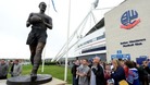 Fans look at the new Nat Lofthouse statue outside the Reebok Stadium