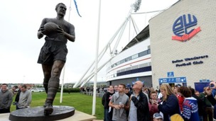 Fans look at the new Nat Lofthouse statue outside the Reebok Stadium
