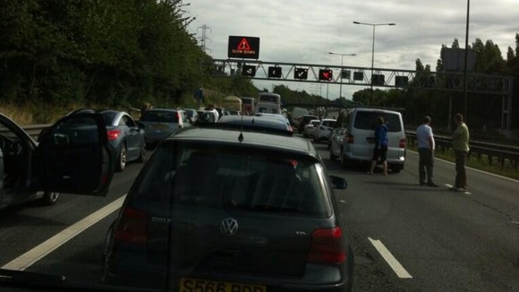 People get out of their cars as traffic hits a standstill on the M6
