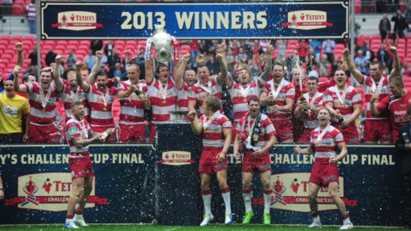 Wigan Warriors celebrate with the trophy after winning the Challenge Cup Final at Wembley Stadium, London.