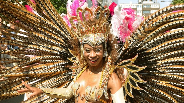 A carnival performer wears long feathers