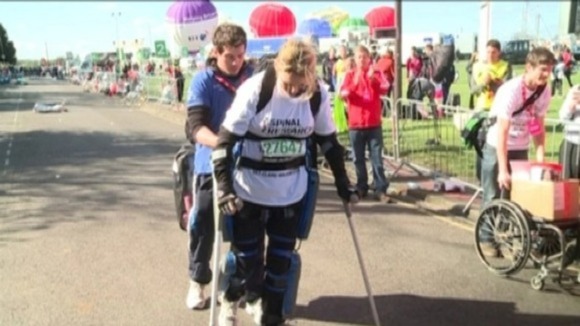 Claire walking in her robotic suit.