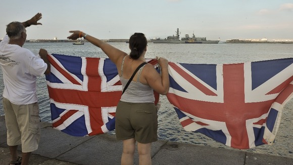 Gibraltarians wave Union Flags as the Royal Navy warship HMS Westminster arrives into the harbour at Gibraltar