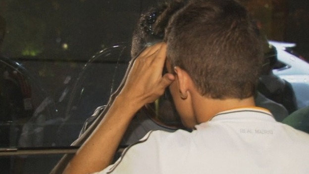 A fan in a Real Madrid shirt looks through a window to catch a glimpse of Bale