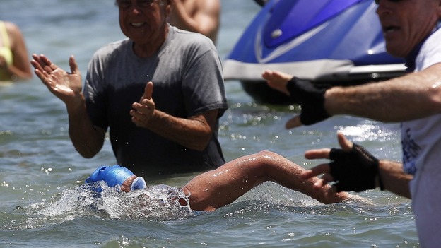 Well-wishers clap as Diana Nyad swims through the crowds at Smathers Beach in Key West.